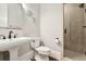 Elegant bathroom featuring a pedestal sink, toilet, and tiled shower with glass door at 29 Cliftwood Dr, Sandy Springs, GA 30328