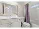 Bathroom featuring a shower with a purple curtain and white tile, a toilet, a vanity, and a large mirror at 29 Cliftwood Dr, Sandy Springs, GA 30328