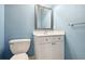 A cozy powder room featuring light blue paint, silver framed mirror, and a white cabinet at 29 Cliftwood Dr, Sandy Springs, GA 30328