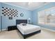 Well-lit bedroom with blue walls, a bed, a window, and decorative wall art at 29 Cliftwood Dr, Sandy Springs, GA 30328