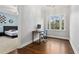 Sunlit bedroom with hardwood floors, a workspace, and large window overlooking greenery at 29 Cliftwood Dr, Sandy Springs, GA 30328