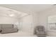 Bright main bedroom with tray ceilings, a plush chair, and sunlit windows with plantation shutters at 29 Cliftwood Dr, Sandy Springs, GA 30328