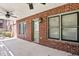Covered patio with brick walls, ceiling fans, and a door leading inside at 29 Cliftwood Dr, Sandy Springs, GA 30328