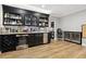 This wet bar features a wine fridge, a stainless steel beverage cooler, and black cabinets at 29 Cliftwood Dr, Sandy Springs, GA 30328
