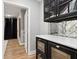 This close up of the bar features a mirrored backsplash, a white countertop, and black cabinets at 29 Cliftwood Dr, Sandy Springs, GA 30328