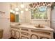 Bathroom featuring dual sinks, a large mirror, and wallpaper at 1007 E Callaway Sw Rd, Marietta, GA 30060