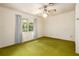 Bedroom featuring a ceiling fan, a window, and worn green carpet at 1007 E Callaway Sw Rd, Marietta, GA 30060