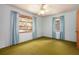 Standard bedroom featuring a ceiling fan, two windows, and worn green carpet at 1007 E Callaway Sw Rd, Marietta, GA 30060