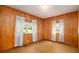 Bedroom featuring paneled walls, two windows, and worn brown carpet at 1007 E Callaway Sw Rd, Marietta, GA 30060