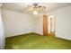 Standard bedroom featuring a ceiling fan, closet, and worn green carpet at 1007 E Callaway Sw Rd, Marietta, GA 30060