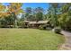 Exterior home elevation with mature tree canopy; lush green front yard at 1007 E Callaway Sw Rd, Marietta, GA 30060