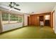 Cozy living room with retro carpet, paneled accent wall and ceiling fan at 1007 E Callaway Sw Rd, Marietta, GA 30060