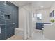 Modern bathroom featuring blue and white tile, a walk-in shower and a window for natural light at 1331 Dayspring Trce, Lawrenceville, GA 30045