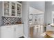 Stylish butler's pantry featuring white cabinets, mosaic backsplash, and stainless steel countertop at 1331 Dayspring Trce, Lawrenceville, GA 30045