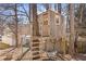 Wooden treehouse in backyard featuring a ladder, rope climbing net and swing at 1331 Dayspring Trce, Lawrenceville, GA 30045