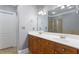 Bathroom with dual sinks, wood cabinetry, a large mirror, and a tiled shower at 1552 Mosaic Way, Smyrna, GA 30080