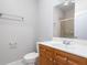 Bathroom featuring a single sink vanity with wood cabinets, a mirror, and a shower with glass doors at 1552 Mosaic Way, Smyrna, GA 30080