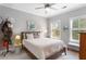 Cozy bedroom with a ceiling fan, bedside table, and two large windows at 1552 Mosaic Way, Smyrna, GA 30080