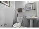 This bathroom features a toilet, a sink, a mirror, and gray walls at 6153 Idlewood Pass, Lithonia, GA 30038