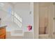 This bathroom features a bathtub, a shower, a window, and white walls at 6153 Idlewood Pass, Lithonia, GA 30038