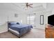 This bedroom features a tray ceiling, a ceiling fan, carpet, and a large bed with a blue comforter at 6153 Idlewood Pass, Lithonia, GA 30038