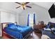 This bedroom features a ceiling fan, a window with blue curtains, and a bed with a blue comforter at 6153 Idlewood Pass, Lithonia, GA 30038