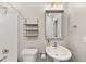 This bathroom features a pedestal sink, decorative mirror and shelving, and a walk-in shower at 1152 Liberty Nw Pkwy, Atlanta, GA 30318