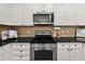 White cabinets, stainless steel microwave and range, and sleek black granite countertop in kitchen at 1152 Liberty Nw Pkwy, Atlanta, GA 30318