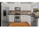 Modern kitchen featuring stainless steel appliances, granite countertops, white cabinetry, and hardwood flooring at 1152 Liberty Nw Pkwy, Atlanta, GA 30318