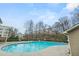 Community pool surrounded by a concrete patio with chairs and a building in the background at 1152 Liberty Nw Pkwy, Atlanta, GA 30318