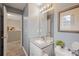 A bathroom featuring granite countertop, white cabinets, framed mirror and well-lit vanity lights at 144 Fox Creek Dr, Woodstock, GA 30188