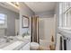 Well-lit bathroom featuring granite countertop, white cabinets, framed mirror and a shower with modern curtain at 144 Fox Creek Dr, Woodstock, GA 30188