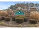 Welcoming Fox Creek community entrance with brick sign and manicured landscaping, showcasing curb appeal at 144 Fox Creek Dr, Woodstock, GA 30188