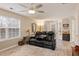 Comfortable living room with luxury black leather seating, ceiling fan, and great natural light at 144 Fox Creek Dr, Woodstock, GA 30188