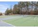 Well-maintained community tennis court surrounded by trees, offering residents a great recreational amenity at 144 Fox Creek Dr, Woodstock, GA 30188