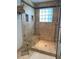 Luxurious shower with tiled walls, glass door, built-in bench, and granite accents at 2690 Twin Creek Ct, Marietta, GA 30062