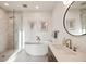 Contemporary bathroom with a soaking tub, a glass-enclosed shower, and a round mirror at 675 Drewry Ne St # 602, Atlanta, GA 30306