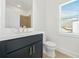 Well-lit bathroom featuring a dark vanity and a window at 2018 Stonecreek Dr, Woodstock, GA 30188