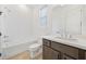 Bright bathroom featuring a tub and shower combo, wood-look floors, and a dark wood vanity with white countertop at 2018 Stonecreek Dr, Woodstock, GA 30188