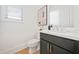 Well-lit half bathroom with a dark vanity, gold fixtures, and decor at 2018 Stonecreek Dr, Woodstock, GA 30188
