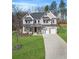 Charming two-story home with a large front lawn, a brick facade, and a two-car garage at 2018 Stonecreek Dr, Woodstock, GA 30188