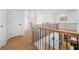 Upstairs hallway with wood flooring, a modern railing, and natural light filtering through the staircase at 2018 Stonecreek Dr, Woodstock, GA 30188