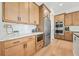 Kitchen area features stainless steel refrigerator and oven alongside stylish wooden cabinetry and stone counters at 2018 Stonecreek Dr, Woodstock, GA 30188