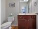 Cozy half bathroom featuring a wood vanity, stylish mirror, and hardwood floors at 3966 Covey Flush Sw Ct # 20, Smyrna, GA 30082