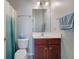 Well-lit bathroom with a wooden vanity, toilet, and a neatly arranged shower curtain at 3966 Covey Flush Sw Ct # 20, Smyrna, GA 30082