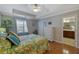 Bedroom featuring tray ceiling, hardwood floors, and view into ensuite bathroom at 3966 Covey Flush Sw Ct # 20, Smyrna, GA 30082