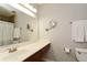 Bathroom with a long white counter, brown vanity and a large mirror at 125 N River Dr # F, Atlanta, GA 30350