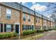 Well-maintained brick townhomes with green entry doors and lush front landscaping at 125 N River Dr # F, Atlanta, GA 30350