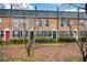 Brick townhomes featuring colorful doors, black shutters, and manicured landscaping at 125 N River Dr # F, Atlanta, GA 30350