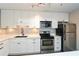Bright kitchen featuring stainless steel appliances, sleek countertops, and white cabinetry at 125 N River Dr # F, Atlanta, GA 30350